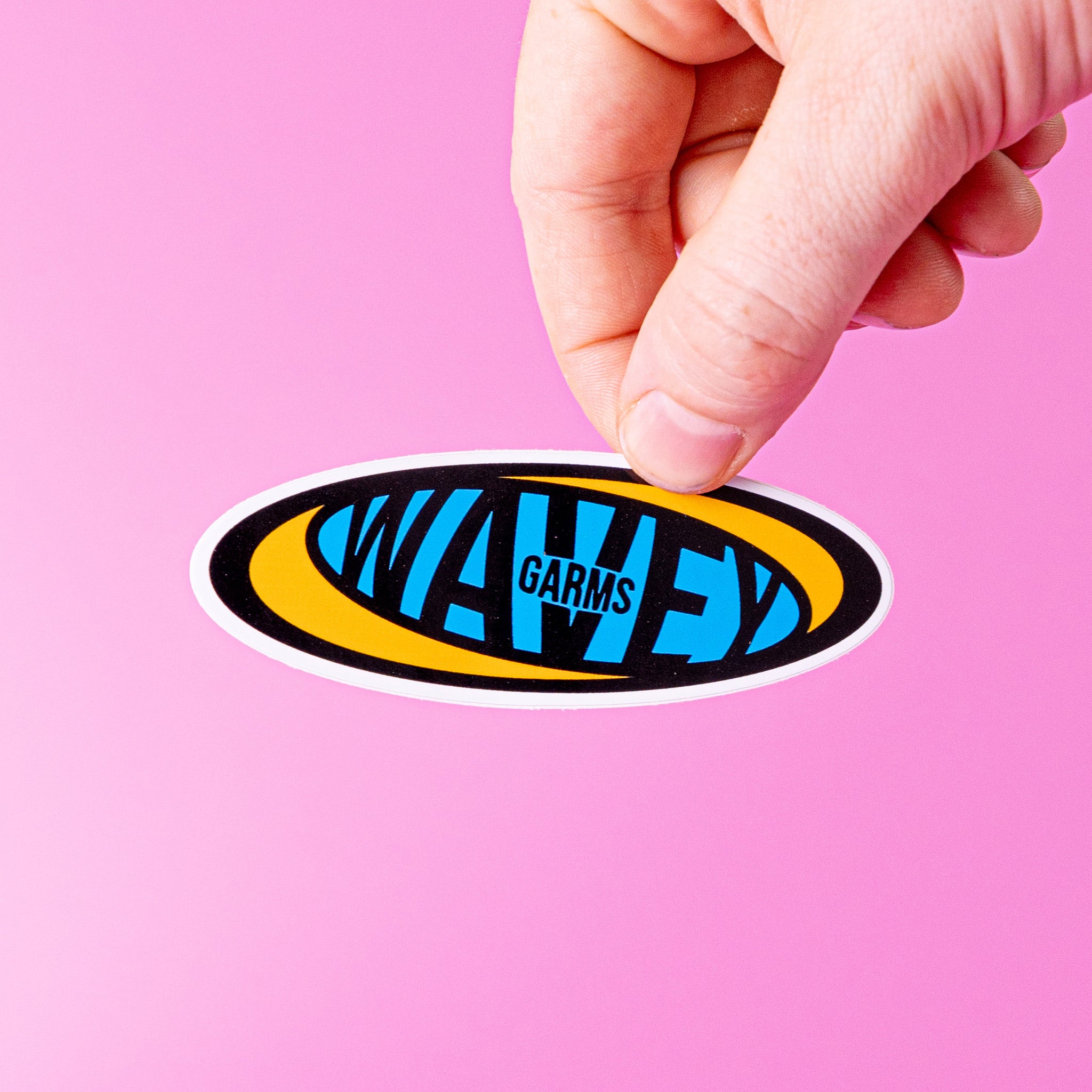 Hand holding a custom vinyl sticker with 'WAVEY GARMS' design on a pink background.